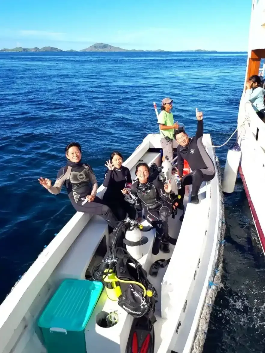 Divers on a tender with tanks, heading to a dive site